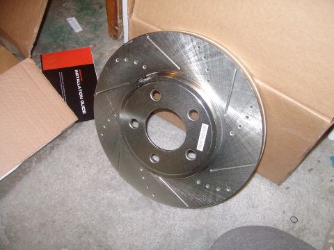 2004 Ford Crown Victoria - A new brake rotor is shown with its installation guide, suggesting it is a replacement part.