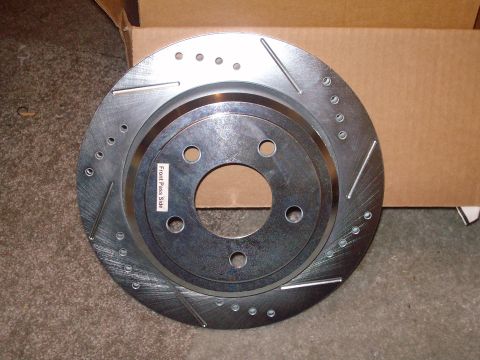 2004 Ford Crown Victoria - A slotted brake rotor, labeled 'Front Pass Side', is shown in a cardboard box.