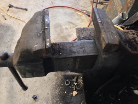 1979 Ford Bronco - A heavy-duty bench vise is clamped to a surface, ready for use in a workshop.
