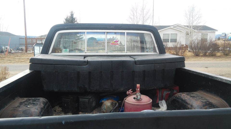 1979 GMC Sierra 1500 pickup truck bed with a black toolbox and red gas cans