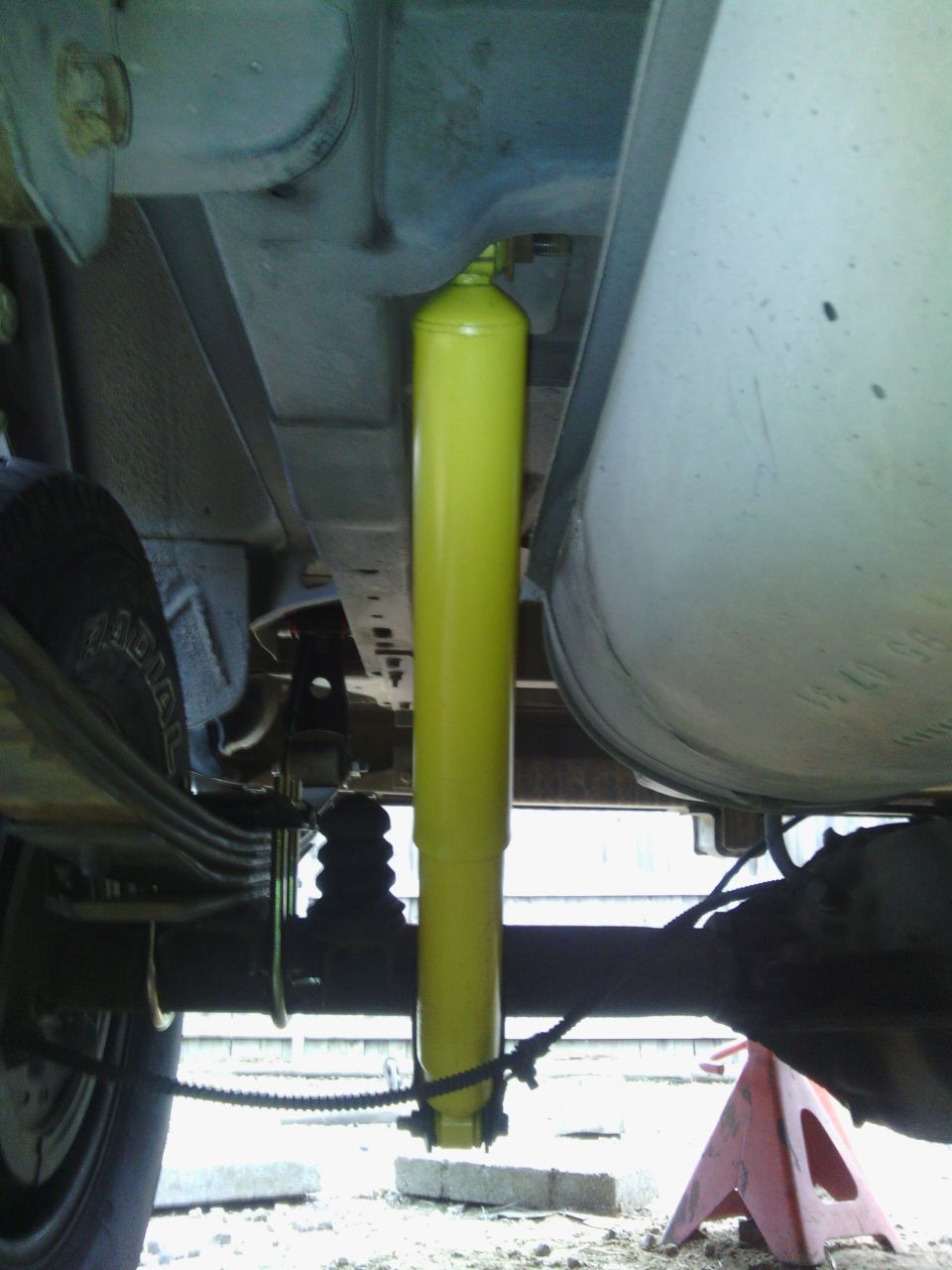Yellow shock absorber visible on the rear suspension of a vehicle