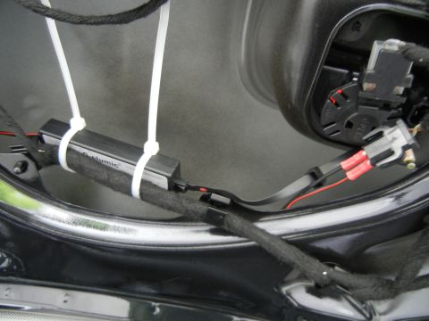 2003 Audi A6 - Close-up view of a car's interior door panel wiring, showing a component labeled "G-elumic" attached with zip ties.