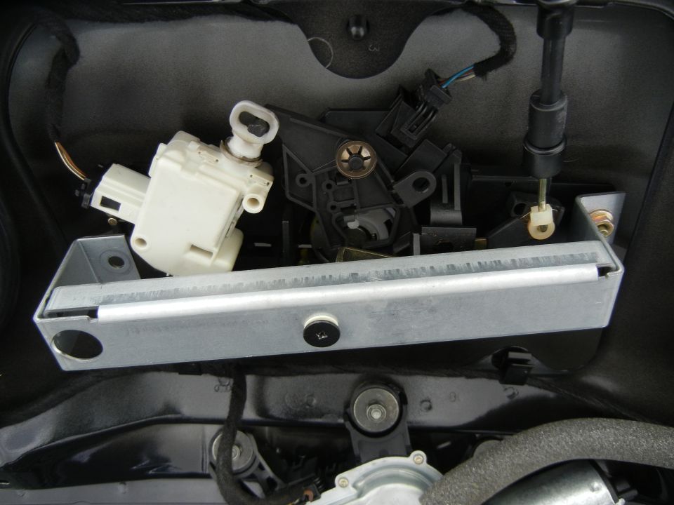Trunk latch mechanism with white actuator and metal bracket