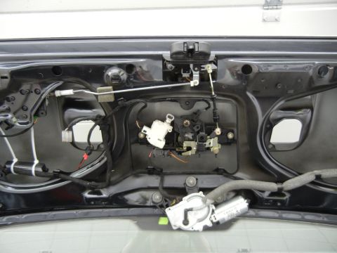 2003 Audi A6 - Close-up view of the trunk's internal latching and locking mechanism, including associated wiring and a motor.