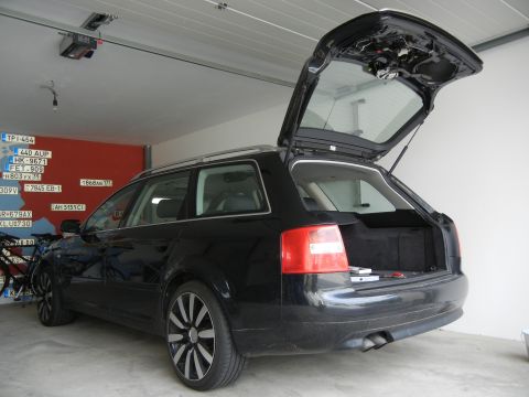 2003 Audi A6 - The rear of a black Audi wagon is shown with its trunk open, parked inside a garage.