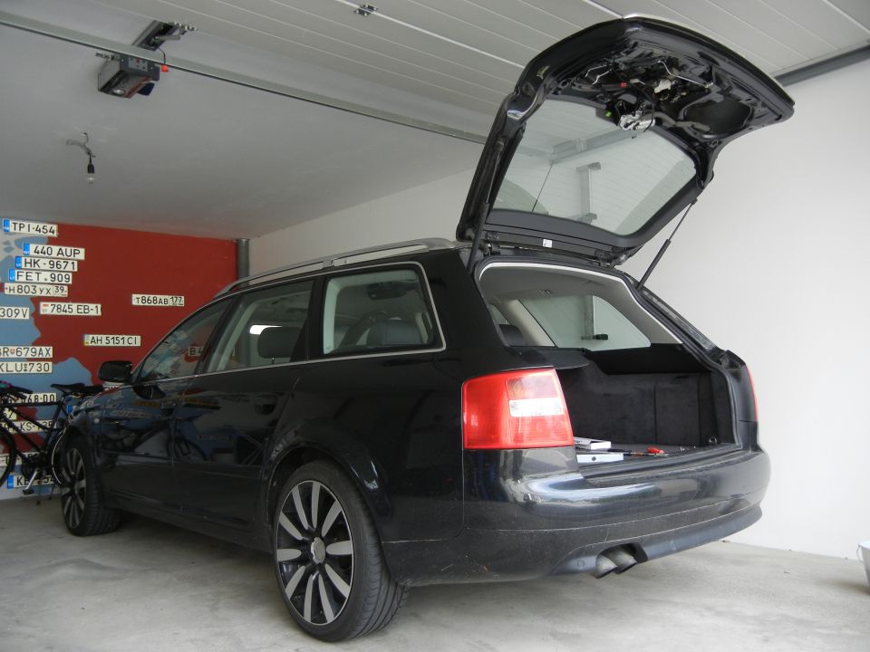 Black Audi A6 Avant wagon with rear hatch open in garage