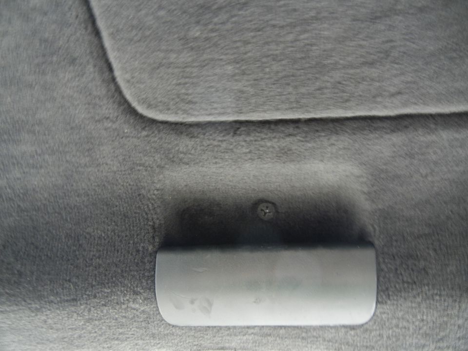 Gray interior trim panel with handle and screw