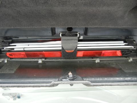 2003 Audi A6 - Car emergency kit with reflective triangle and straps, likely stored in a trunk or undercarriage compartment.