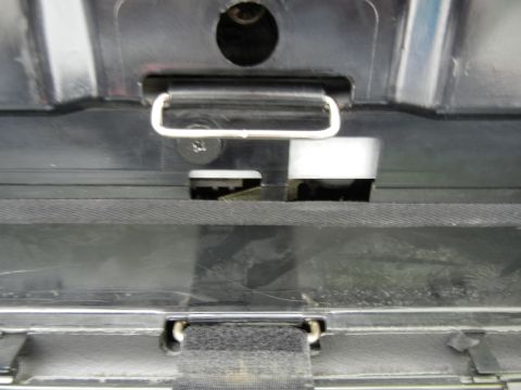 2003 Audi A6 - The image shows a close-up view of a vehicle's trunk latch mechanism, including a metal hook and various plastic components.