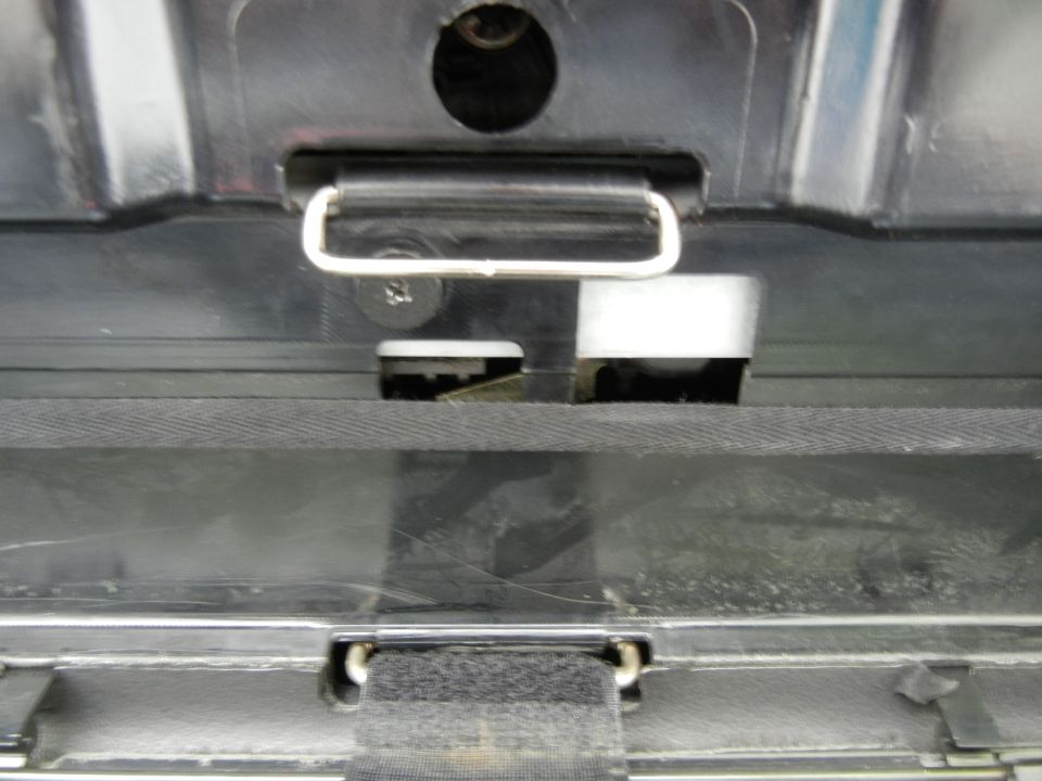 Close-up of a car's trunk latch mechanism with a metal hook and plastic parts