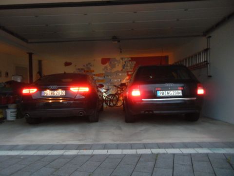 2003 Audi A6 - Two Audi wagons are parked in a garage, their brake lights illuminated. The license plate on the right vehicle reads PB-WG 2006.