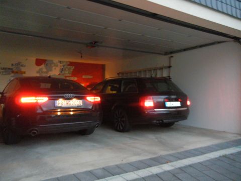 2003 Audi A6 - Two Audi station wagons are parked side-by-side in a garage, their taillights illuminated.