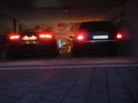 2003 Audi A6 - Two Audi sedans are parked in a garage with a bicycle between them.