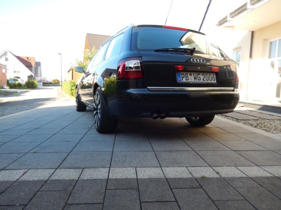 Black 2003 Audi A6 wagon parked on a paved driveway, rear view