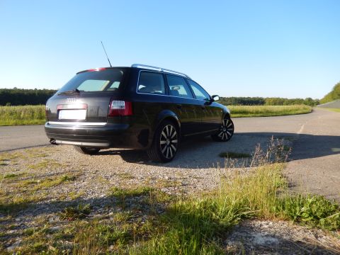 2003 Audi A6 - A black 2003 Audi A6 station wagon is parked on a gravel shoulder next to a paved road.