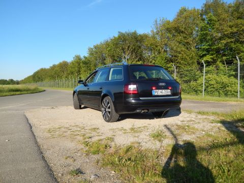 2003 Audi A6 - A black Audi wagon is parked on a gravel patch next to a road, with a fence and trees in the background. The license plate reads PB WG 2006.