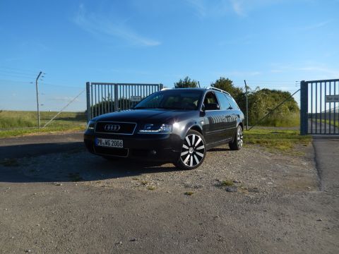 2003 Audi A6 - 2003 Audi A6 Avant wagon parked outdoors near industrial gates under a clear blue sky.