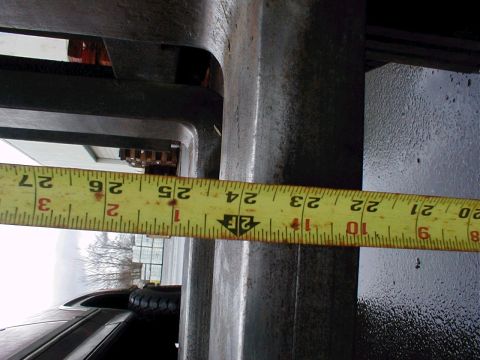 1983 Ford Bronco - A measuring tape is used to measure a metal component, with the tape reading approximately 24 inches.