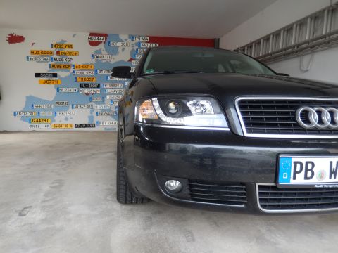 2003 Audi A6 - A black Audi A6 is parked in front of a wall decorated with a map of Europe and various license plates.