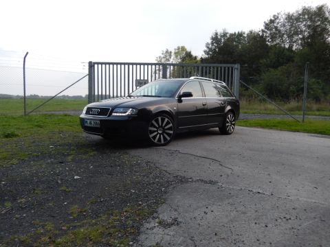 2003 Audi A6 - A dark station wagon with distinctive wheels is parked in front of a large metal gate. The license plate is visible and shows 'PB-MS 2006'.