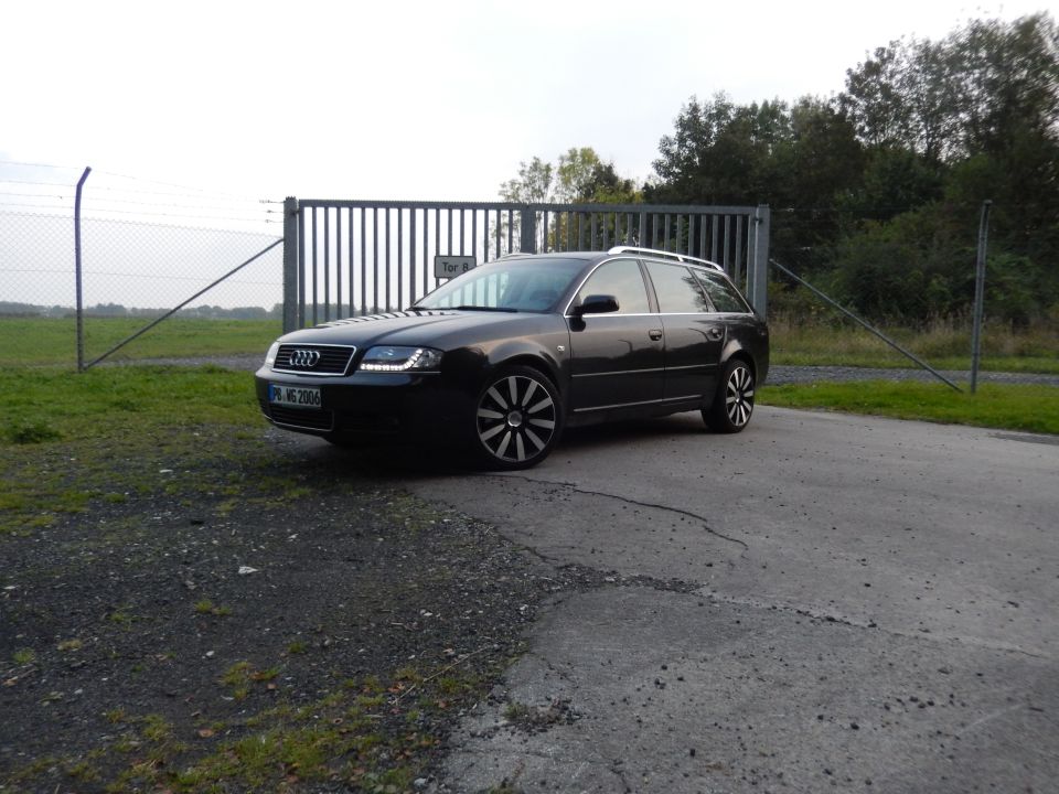 Dark station wagon with custom wheels parked near a gate. License plate reads 'PB-MS 2006'