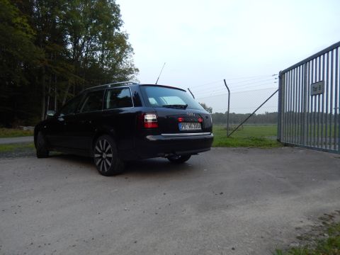 2003 Audi A6 - Rear view of a black 2003 Audi A6 wagon parked near a gate.
