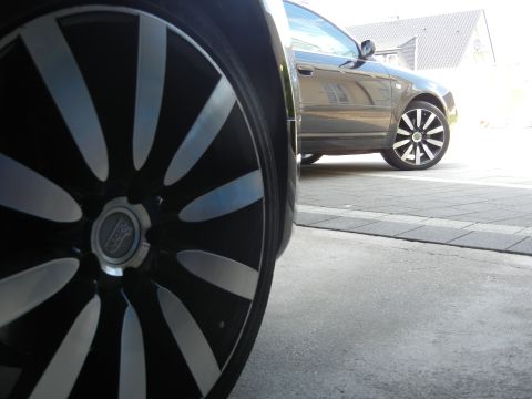 2010 Audi A4 - A dark sedan is parked outside, with a focus on its custom alloy wheels.
