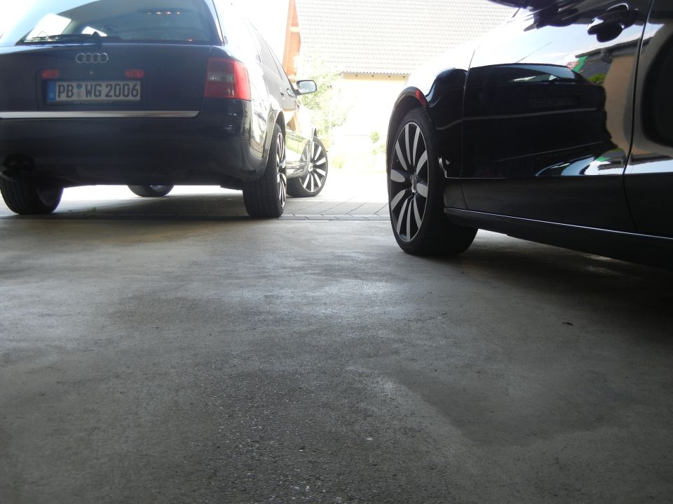 Rear view of a black Audi A6 wagon with license plate PB WG 2006, parked next to another black car