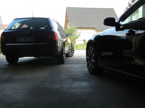 2010 Audi A4 - Two black Audi wagons are parked side-by-side in a garage, one showing its rear with a visible license plate.