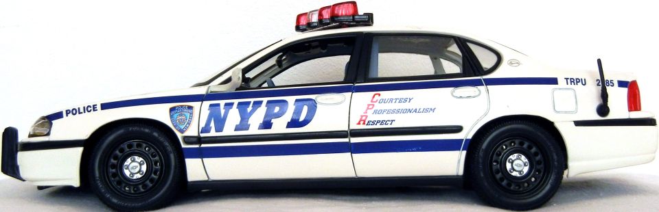Side view of NYPD police car with blue stripes and "NYPD" text