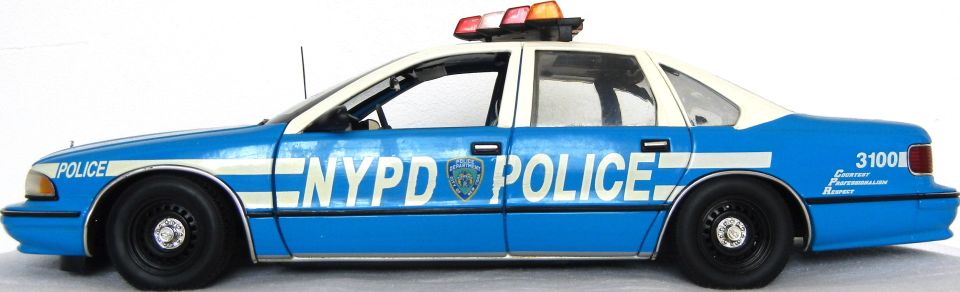 Blue and white NYPD police car, side view, with "POLICE" and "NYPD POLICE" text