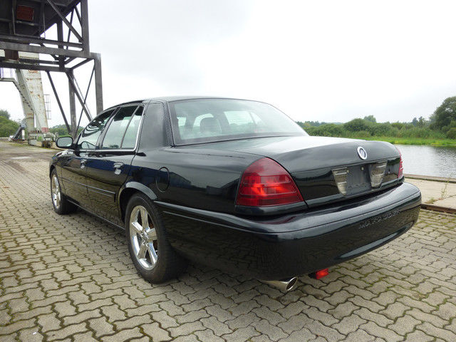 Black 2003 Mercury Marauder parked on brick pavers near water