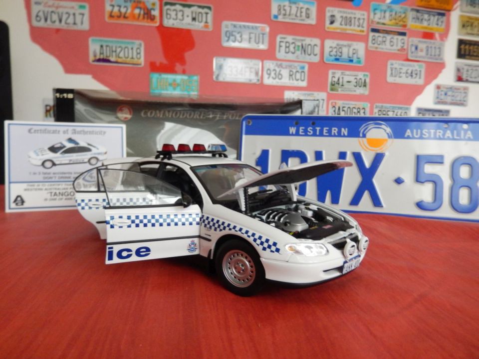 White police car model with doors open and hood up, showing engine detail