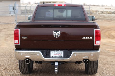 2015 Dodge 1500 - Rear view of a brown Dodge Ram pickup truck with a chrome bumper and dual exhaust pipes.