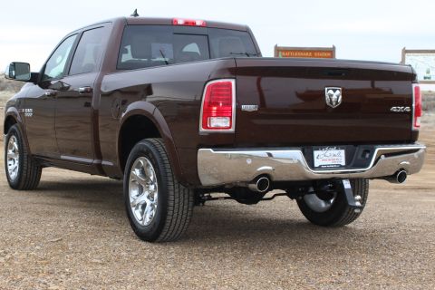 2015 Dodge 1500 - Rear view of a brown Ram 1500 pickup truck, showing the tailgate, taillights, and chrome bumper.
