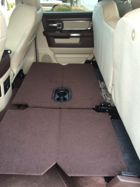 2015 Dodge 1500 - The rear floor of a 2015 Dodge 1500 is shown with the seats folded down, revealing a flat cargo area with a built-in cup holder.
