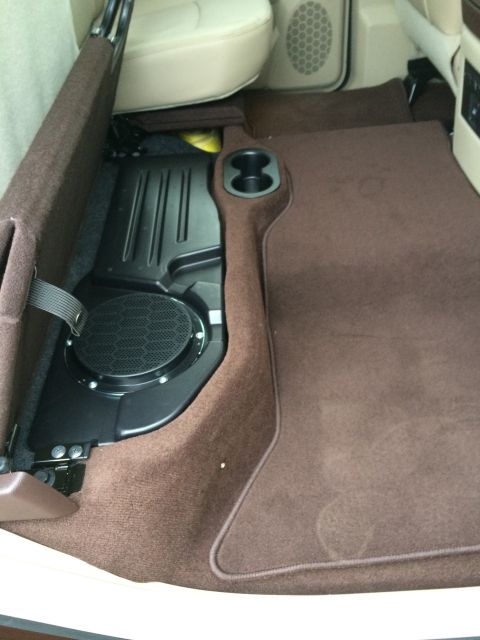 2015 Dodge 1500 - The rear floor of a vehicle is visible, a subwoofer and brown carpeting.