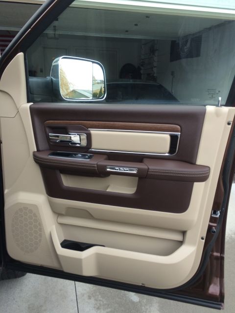2015 Dodge 1500 - Interior door panel of a 2015 Dodge 1500, leather, wood trim, and a Ram logo.