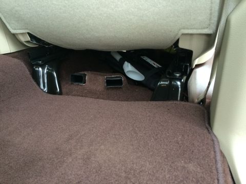 2015 Dodge 1500 - Interior view of a vehicle's under seat area, showing carpet and metal components.