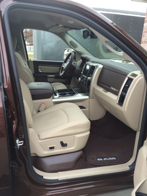 2015 Dodge 1500 - The interior of a Ram truck features tan leather seats and a brown dashboard with a large infotainment screen.