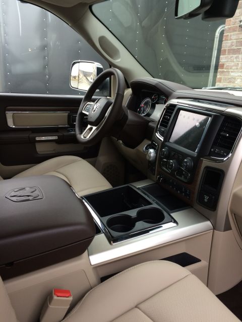 2015 Dodge 1500 - The interior of a 2015 Dodge 1500 truck features tan leather seats and a wood-grain accented dashboard.