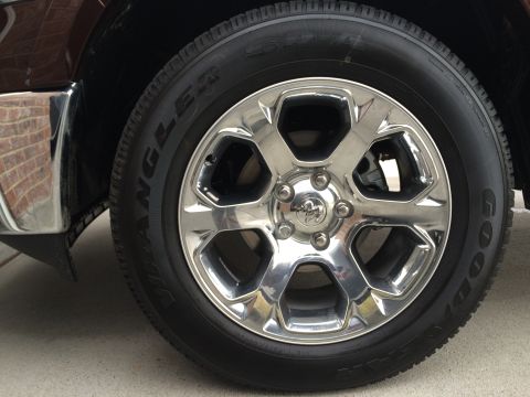 2015 Dodge 1500 - Close-up of a chrome wheel and tire on a dark brown 2015 Dodge 1500.
