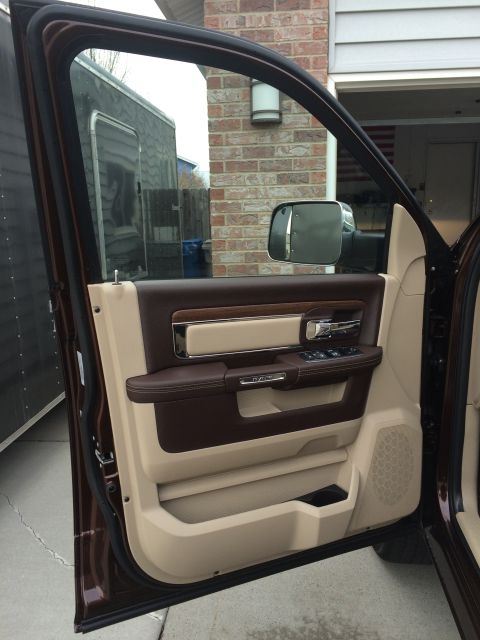 2015 Dodge 1500 - The interior door panel of a truck features two-tone brown and tan upholstery with chrome accents.
