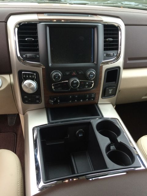 2015 Dodge 1500 - The center console of a 2015 Dodge 1500 features wood grain trim, chrome accents, and a touchscreen display.
