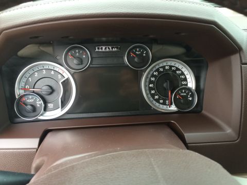 2015 Dodge 1500 - The interior dashboard of a Ram truck shows various gauges including the speedometer and tachometer.