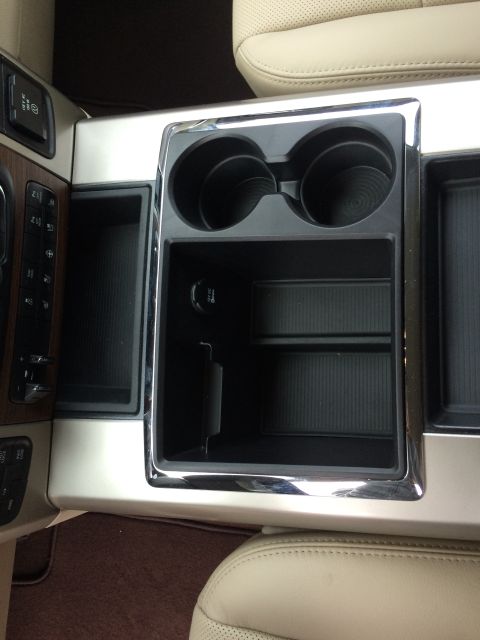 2015 Dodge 1500 - Close-up of the center console in a vehicle, showing cup holders and storage compartments.