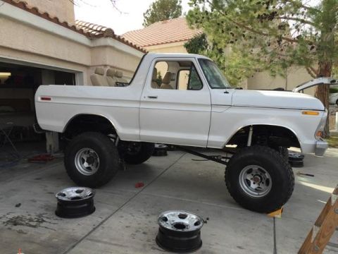 1979 Ford Bronco - This lifted 1978 Ford Bronco is undergoing maintenance with spare wheels nearby.