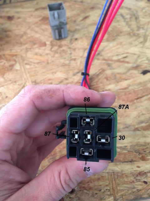 1994 Ford Bronco - Close-up of a hand holding a relay socket with labeled pins and attached wires.