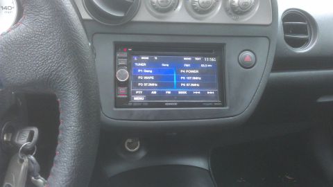 1994 Ford Bronco - The interior of a car shows a Kenwood stereo system with preset radio stations displayed on its screen.