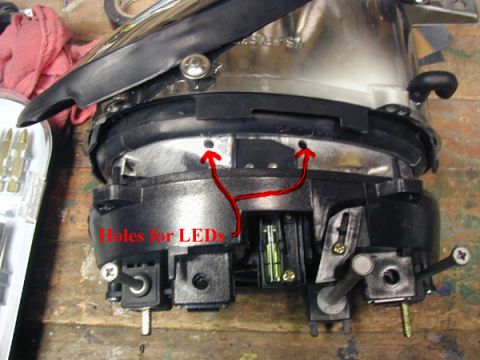1998 Ford Taurus - This image shows a headlight assembly being modified for LED installation, with specific points marked for the new lights.